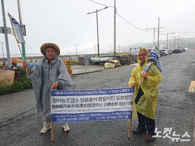 이원영 전 수원대 교수(왼쪽)과 이승렬 대구환경운동연합 상임대표가 13일 부산시 기장군의 한 도로에서 현수막을 들고 일본의 원전 오염수 방류 중단을 촉구하고 있다. 이상록 기자