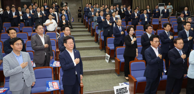 이재명 더불어민주당 대표와 의원들이 13일 오전 서울 여의도 국회에서 열린 정책의원총회에서 국기에 대한 경례를 하고 있다. 연합뉴스