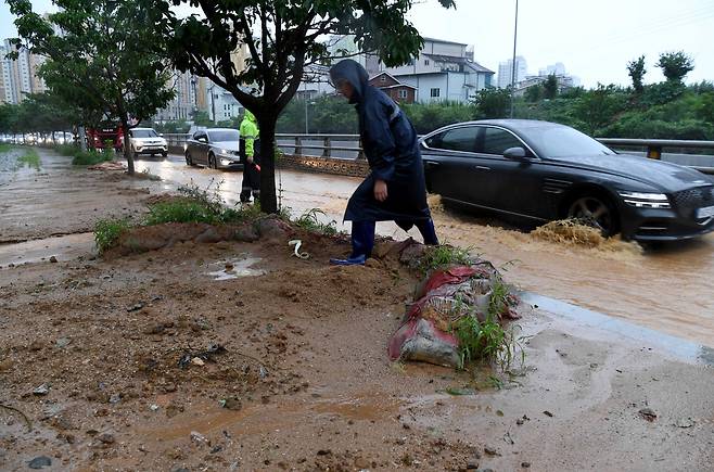 폭우가 내린 14일 오전 광주 북구 신용동 신용지하차도 옆 1차선 도로(북광주IC 방면) 일대가 인근 경사면에서 흘러내린 토사로 인한 흙탕물이 들어 차 있다. /뉴시스