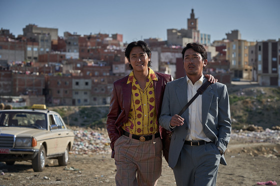 Ju Ji-hoon, left, plays Kim Pan-soo, a taxi driver who gets involved in Lee Min-joon's mission to deliver a ransom and rescue a Korean diplomat in ″Ransomed.″ Ha Jung-woo, right, plays Min-joon. [SHOWBOX]