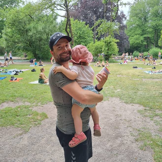 독일 바이에른주 뮌헨 ‘영국 정원(Englischer Garten)’에서 만난 공무원 하랄드(Harald·36)씨가 아이를 안고 포즈를 취하고 있다. 아내와 나눠쓸 수 있는 14개월의 휴직 중 2개월의 ‘육아휴직’을 사용했다는 하랄드 씨는 “공무원이 아닌 민간 기업에 다니는 친구들 중에서도 육아휴직을 쓰지 못한 경우는 한번도 보지 못했다”고 말했다. [사진=김용훈 기자]