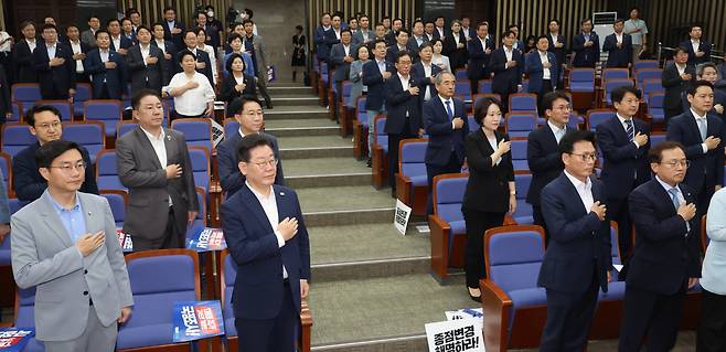 이재명 더불어민주당 대표와 의원들이 13일 오전 서울 여의도 국회에서 열린 정책의원총회에서 국기에 대한 경례를 하고 있다. [연합]