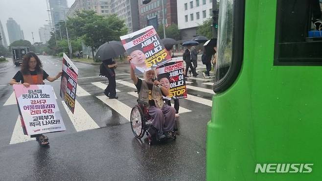 [서울=뉴시스] 서울 여의도 국회 인근에서 버스 운행을 막는 기습 시위를 벌인 박경석 전국장애인차별철폐연대 대표가 14일 서울 영등포경찰서에 현행범 체포됐다.(사진=전국장애인차별철폐연대 제공) 2023.07.14.