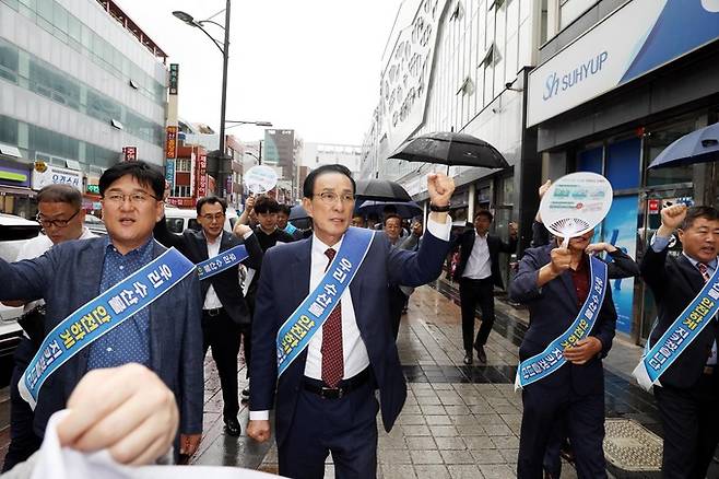 우리 수산물 지키기 운동본부가 14일 부산시수협 자갈치위판장에서 ‘수산물 지키기 릴레이 캠페인’을 개최한 가운데 노동진 수협중앙회장(왼쪽 두번째)과 참석자들이 ‘2011년부터 현재까지 약 3만 건의 수산물 방사능 검사 결과 기준치에 모두 적합’하다는 내용이 담긴 부채를 들고 가두 행진을 하고 있다. 수협 제공