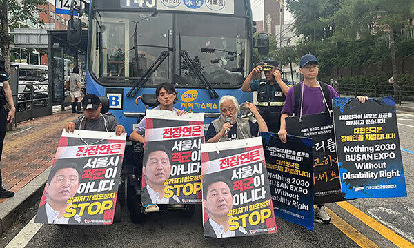 전국장애인차별철폐연대(전장연) 활동가들이 13일 오전 서울 종로구 혜화동로터리 중앙버스전용차로에서 오세훈 시장을 규탄하며 시내버스를 막아서고 있다. 연합뉴스