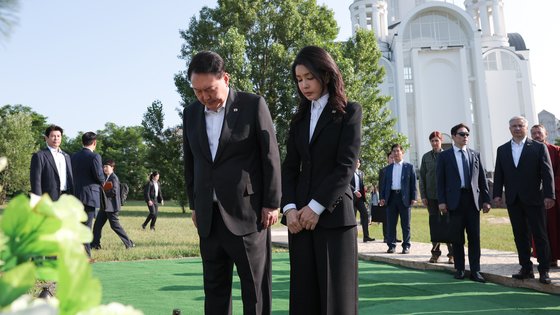 윤석열 대통령과 부인 김건희 여사가 15일(현지시간) 키이우 인근 부차를 방문해 희생자들 무덤에 조성된 추모공간에서 묵념하고 있다. 사진 대통령실