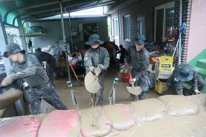 [서울=뉴시스] 육군 2작전사령부 50사단 장병들이 집중 호우로 인해 토사가 밀려든 경북 예천군 감천면 가옥과 도로에 토사를 걷어내고 있다. (사진=육군 제공) 2023.07.15. photo@newsis.com  *재판매 및 DB 금지