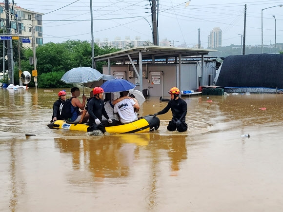 15일 많은 비로 침수 피해가 발생한 충남 공주시 옥룡동 다세대 주택 단지에서 119 대원들이 보트를 이용해 구조작업을 벌이고 있다. 2023.7.15 독자 제공 연합뉴스