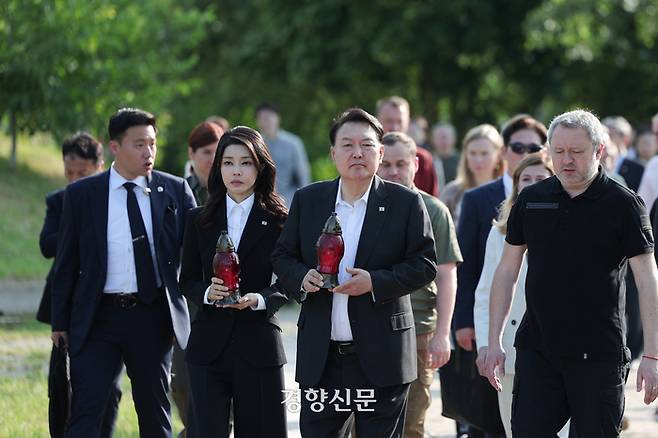 폴란드 순방을 마친 윤석열 대통령과 부인 김건희 여사가 15일(현지시간) 전쟁 중인 우크라이나 키이브주의 도시 부차의 공동묘지에서 추모하고 있다. 대통령실제공