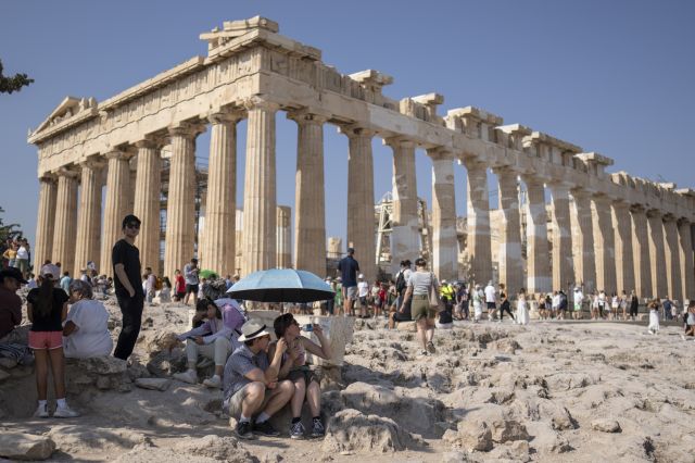 지난 13일(현지시간) 그리스 아테네 아크로폴리스 언덕에 있는 파르테논 신전 앞에서 관광객들이 양산을 쓰고 물을 마시고 있다. AP연합뉴스