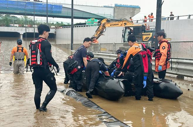 16일 폭우로 침수된 청주시 흥덕구 오송읍 궁평2 지하차도 앞에서 소방 관계자들이 이날 수색작업을 시작하고 있다. [사진 출처 = 소방청, 연합뉴스]