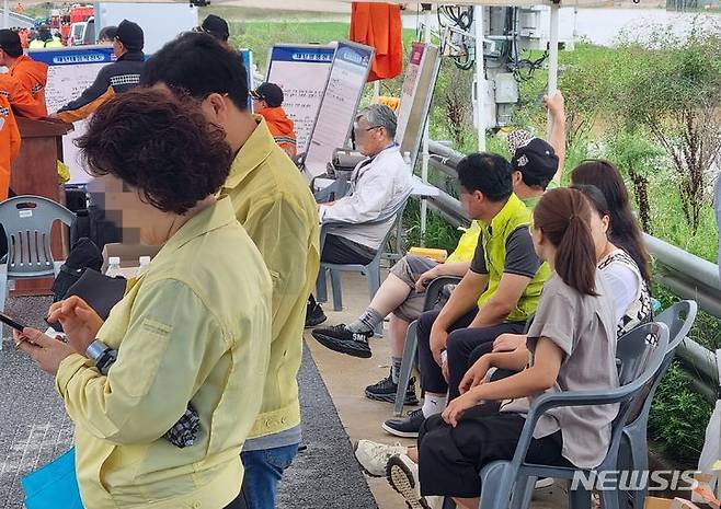 [청주=뉴시스] 안성수 기자 = 16일 미호천 범람으로 차량 십수대 침수 사고가 발생한 충북 청주시 오송 궁평2지하차도에서 실종자 가족들이 현장을 애타게 쳐다보고 있다. 2023.7.16. hugahn@newsis.com
