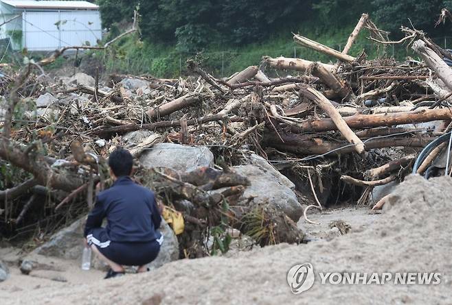 산사태에 휩쓸린 고향 (예천=연합뉴스) 윤관식 기자 = 16일 오전 경북 예천군 감천면 벌방리 마을이 산사태로 초토화된 가운데 한 주민이 주저앉아 있다. 2023.7.16 psik@yna.co.kr