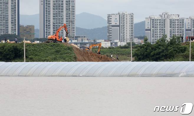 16일 오후 충남 논산시 성동면 원봉리 일대에 논산천 제방이 무너지면서 침수피해가 발생한 가운데 관계자들이 중장비를 동원해 무너진 제방을 복구하고 있다. 2023.7.16/뉴스1 ⓒ News1 장수영 기자