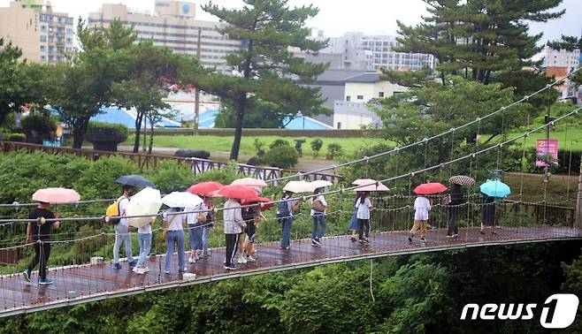 호우특보가 발효된 8일 오전 관광객들이 우산을 쓰고 제주시 용담동 용연다리를 건너고 있다.2023.7.8/뉴스1 ⓒ News1 고동명 기자