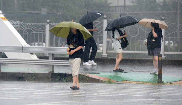 전북 대부분 지역에 호우경보가 발효된 지난 14일 전북 전주시 완산구 효자동에서 학생들이 우산으로 비를 피하며 길을 지나고 있다. [사진=뉴시스]