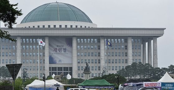 국회 본관 건물에 제75주년 제헌절을 앞두고 대형 현수막이 내걸려 있다. 국회 앞에는 각종 이익단체 등이 천막 농성을 벌이고 있을 정도로 사회 갈등이 심각하다. 헌법에서 해법을 찾을 수 없을까. 장세정 기자