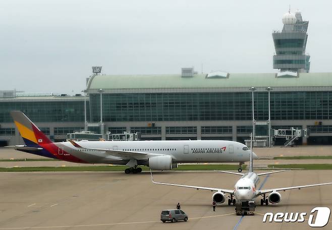 (인천공항=뉴스1) 박정호 기자 = 16일 오후 인천국제공항 1터미널 전망대에서 바라본 활주로에서 아시아나항공 항공기가 움직이고 있다.   임금협상 결렬에 따른 아시아나항공 조종사노조 쟁의행위의 여파로 이날 오전 7시35분 인천국제공항을 출발해 오전 11시5분 베트남 호찌민 현지에 도착할 예정이던 OZ731편이 조종사노조 단체행동으로 인해 결항됐다.  조종사노조가 지난달 7일 쟁의행위를 시작한 이후 국제선 결항이 발생한 것은 이번이 처음이다. 2023.7.16/뉴스1  Copyright (C) 뉴스1. All rights reserved. 무단 전재 및 재배포 금지.