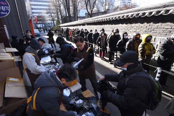 서울 종로구 원각사 무료급식소에서 열린 방한용품세트 나눔 행사에서 어르신들이 방한용품을 받기 위해 줄 서 있다. 2022.12.14 홍윤기 기자