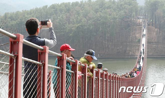 경기 파주시 마장호수 흔들다리에서 시민들이 다리를 건너고 있다. 마장호수 흔들다리는 사람이 걸어서 건널 수 있는 국내 최장 길이의 현수교로 길이 220m, 폭 1.5m다. 2018.3.29/뉴스1 ⓒ News1 신웅수 기자