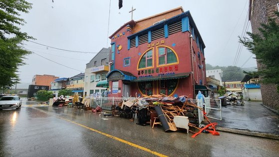 18일 오전 강한 비가 내리는 가운데 폭우로 침수 피해를 입은 충남 공주시 옥룡동에 치우지 못한 쓰레기가 산더미처럼 쌓여 있다. 신진호 기자