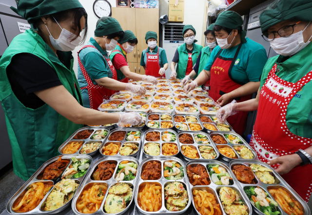 수원 평동새마을부녀회 회원들이 18일 경기도 수원시 평동행정복지센터에서 ‘사랑의 119 반찬 나눔’ 행사를 열고 관내 취약 계층에 전달 할 반찬을 포장하고 있다. 수원=연합뉴스