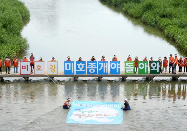 미호강 주민하천관리단이 12일 충북 청주시 상당구 무심천 일대에서 미호강의 유역관리를 위한 수중 퍼포먼스를 하고 있다. 청주= 뉴시스