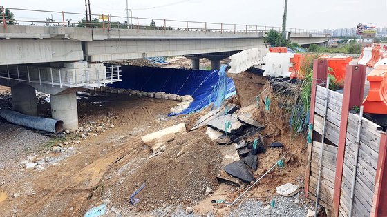 지난 15일 오전 폭우로 유실된 청주 미호강 미호천교 아래의 제방. 이 제방은 행정중심복합도시건설청이 미호천교를 건설하면서 기존의 제방을 헐어 공사차량 등의 통로로 사용하다 장마를 앞두고 임시로 만든 제방이다. 연합뉴스