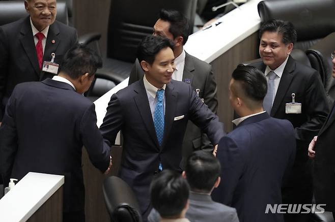 [AP/뉴시스] 태국 전진당의 피타 림짜른랏 대표가 총리선임 2차 투표일인 19일 헌재로부터 '의원직 일시정지' 판결을 받은 뒤 의회서 동료 의원들과 작별 악수하고 있다. 2023. 07. 19.