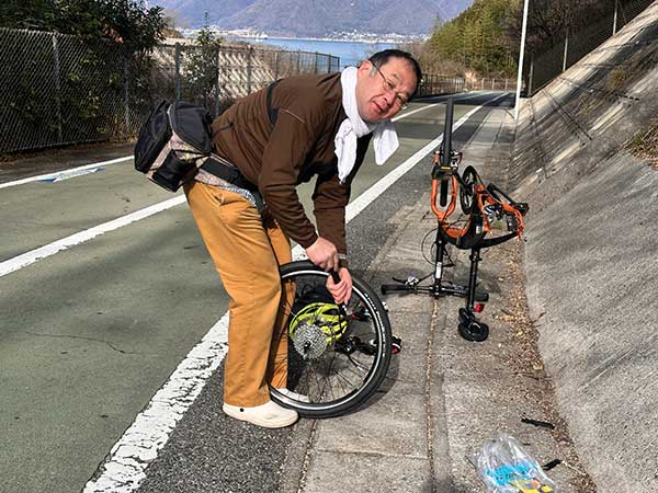 인노시마대교 진입로에서 펑크 난 타이어를 수리하고 있는 라이더. 타이어 펑크 수리에 필요한 도구는 항상 휴대하고 다닌다고 한다.