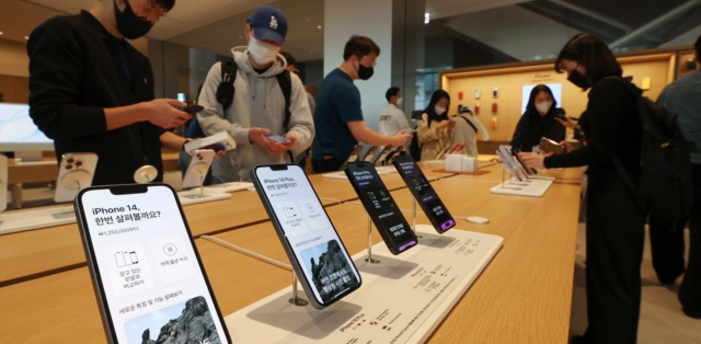 애플의 신제품 아이폰14 시리즈 공식 출시일인 7일 오전 서울 중구 명동 애플스토어에서 고객들이 제품을 살피고 있다. 연합뉴스