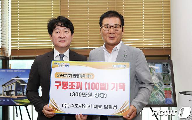 엄필성 수도씨엔지 대표(왼쪽)이 20일 이상익 함평군수에 구명조끼 100벌을 기탁했다.(함평군 제공)2023.7.20./뉴스1