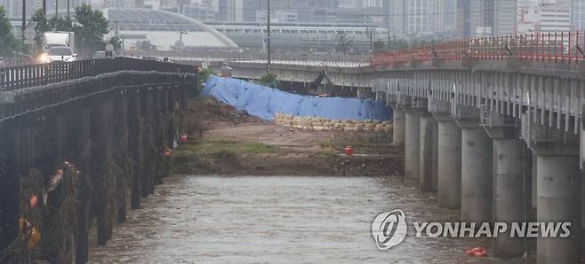 미호강 임시제방 (청주=연합뉴스) 서대연 기자 = 18일 오후 충북 청주시 미호천교 아래에 임시제방이 쌓여있다.
    지난 15일 폭우로 미호강 제방이 무너지며 강물이 궁평2지하차도를 덮쳐 24명의 사상자가 발생했다. 2023.7.18 dwise@yna.co.kr