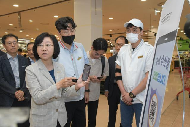 오유경(왼쪽) 식품의약품안전처장이 21일 서울 중구의 롯데마트 서울역점을 찾아 수산물 방사능 검사 확인 QR코드를 시연하고 있다. 식약처 제공