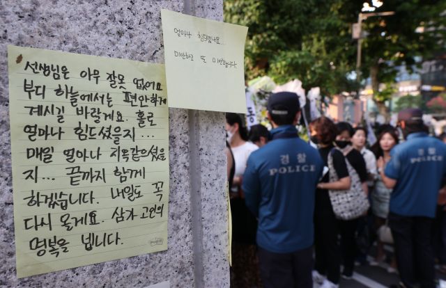 20일 오후 서울 서초구 서이초등학교에 마련된 임시 추모공간에서 추모객들이 고인이 된 A교사를 추모하고 있다. 연합뉴스