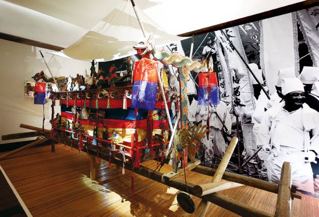 쉼박물관에 상설 전시돼 있는 상여. 그 뒤로 전통 장례 모습을 담은 사진이 보인다.   쉼박물관 제공