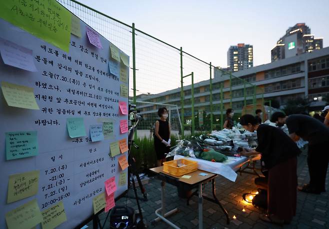 지난 20일 오후 서울 서초구 서이초등학교에 마련된 임시 추모공간에 고인이 된 교사 A씨를 기리는 추모객들의 발길이 이어지고 있다. 임시 추모공간 옆에 21일부터 강남서초교육지원청에 추모공간을 마련한다는 안내문이 게시돼 있다. 교육계에 따르면 이 학교 담임 교사 A씨가 학교 안에서 극단적 선택을 해 숨지는 일이 발생했다. [연합뉴스]