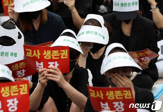 22일 오후 서울 종로구 보신각 앞에서 전국교사모임 주최로 열린 서초 서이초 교사 추모식 및 교사생존권을 위한 집회에서 참가자들이 눈물을 훔치고 있다. 2023.7.22/뉴스1 ⓒ News1 구윤성 기자