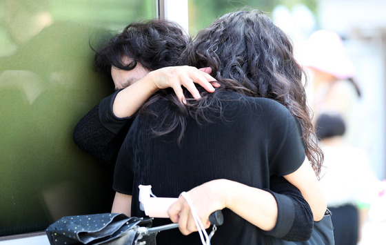 Teachers shed tears in front of Seo 2 Elementary School in Secho District, Seoul, on Friday where many have shown up to express their condolence to the teacher that died by suicide on Tuesday. The teacher’s death has raised the issue of the collapsed teachers’ rights. [NEWS1]