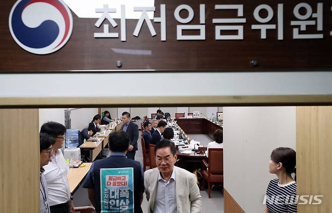 [세종=뉴시스] 강종민 기자 = 지난 18일 세종시 정부세종청사에서 열린 최저임금위원회 전원회의. 정회가 선언되자 위원들이 밖으로 나오고 있다. 2023.07.18. ppkjm@newsis.com