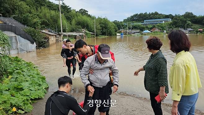 24일 전남 영광군 군남면의 한 마을이 진입로가 침수되자 소방관들이 업어서 주민들을 구조하고 있다. 전남소방본부 제공.