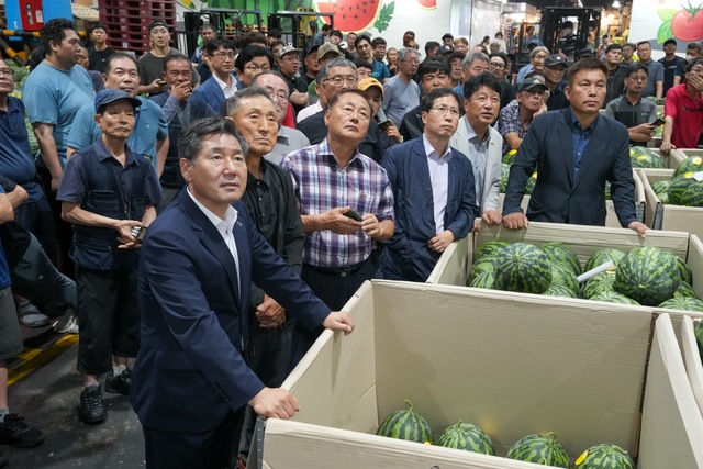 서울 가락동 농수산물도매시장 과일경매장을 찾은 서흥원 양구군수(맨 앞줄 왼쪽 첫번째), 박성용 양구군농협 조합장(〃 세번째부터), 손이옥 NH농협 양구군지부장 등이 수박 경매가를 살펴보고 있다.