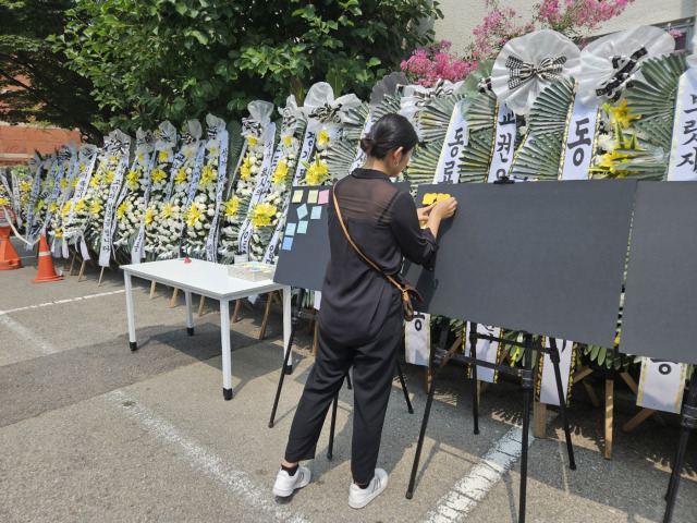 21일 서울 서초구 서이초 앞 추모공간에서 한 추모객이 교내에서 숨진 서이초 교사에게 전하는 메시지를 붙이고 있다. 정유민 기자