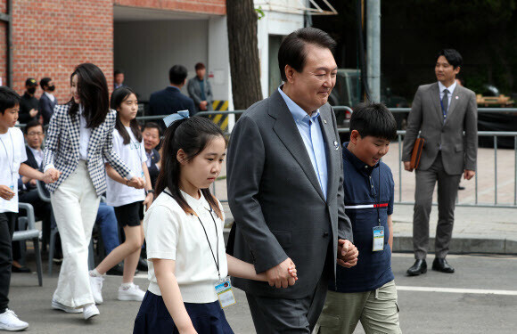 윤석열 대통령이 4일 용산어린이정원 개방 행사에서 어린이들의 손을 잡고 입장하고 있다. 연합뉴스