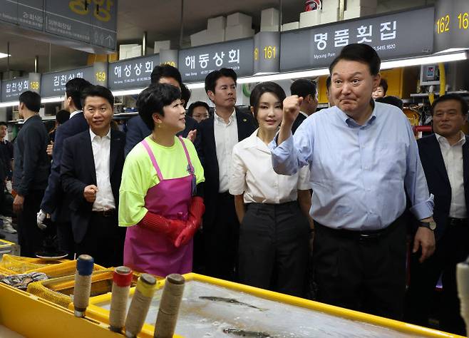 윤석열 대통령과 김건희 여사가 27일 부산 중구 자갈치시장을 찾아 수산물 시장 상황을 점검하며 상인들을 격려하고 있다. (사진=연합뉴스)