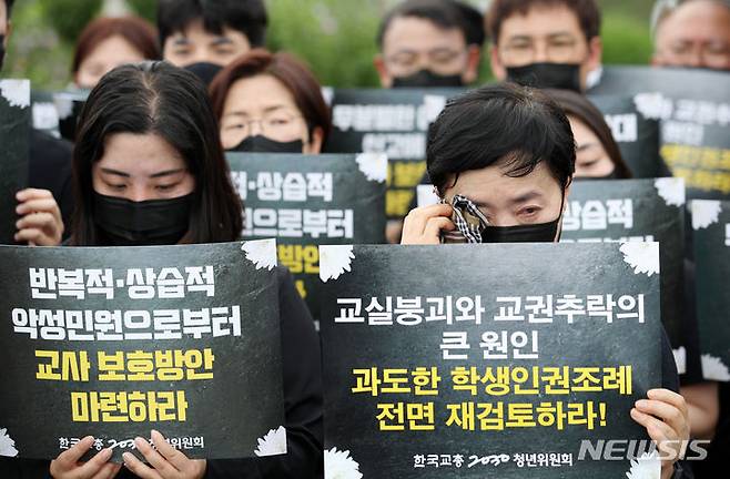 [서울=뉴시스] 조성우 기자 = 27일 오후 서울 영등포구 여의도 국회 앞에서 한국교총 2030청년위원회 주최로 열린 실질적인 교권 보호 대책 마련 촉구 기자회견에서 한 참가자가 땀을 닦고 있다. 2023.07.27. xconfind@newsis.com