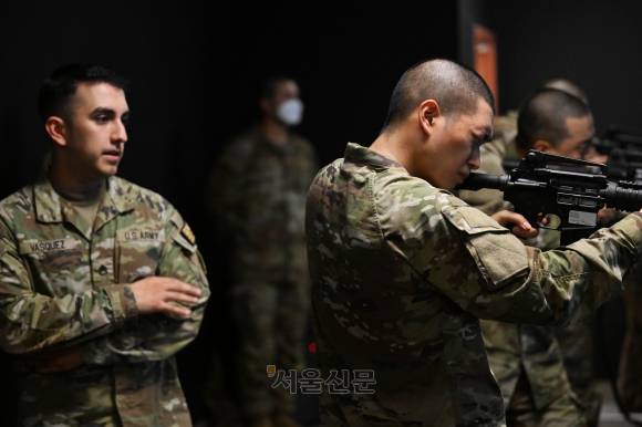 한 카투사교육대 교육생이 지난 21일 경기도 평택시 캠프 험프리스 내 교전능력숙달센터 실내사격장에서 미군 교관의 도움을 받으며 미군 소총 M4로 사격 훈련을 하고 있다.