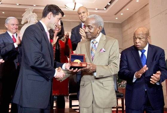 2016년 미국 국회의사당에서 황금훈장을 받은 흑인 인권운동가 프레더릭 리스(가운데)와 황금훈장. 리스는 마틴 루서 킹 목사와 함께 1965년 흑인 참정권 운동을 이끌었다. 훈장에 당시 행진 모습이 담겨 있다. [AP=연합뉴스]