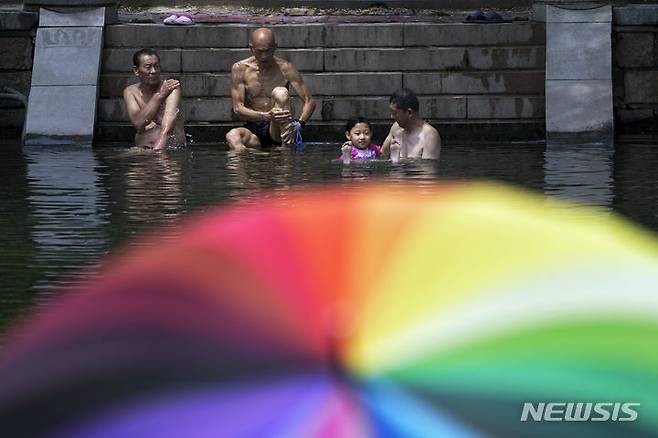 [베이징=AP/뉴시스] 3일 중국 베이징 주민들이 동네 수로에서 물놀이를 하며 더위를 식히고 있다. 중국 국가기후센터(NCC)는 베이징 기온이 열흘째 35도를 넘었다고 밝혔다. 2023.07.03.