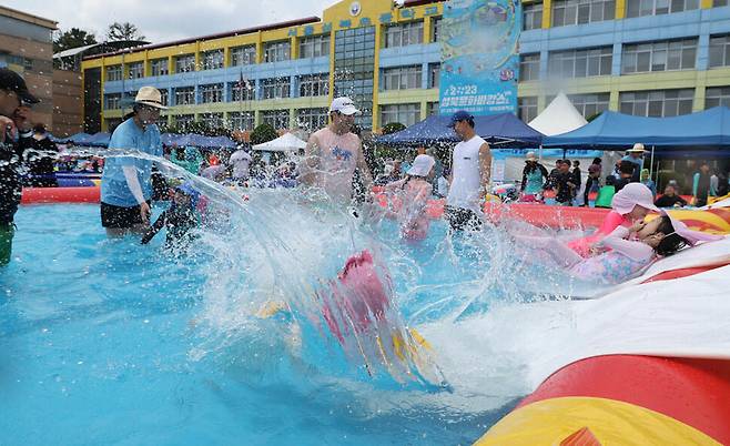 전국 대부분 지역에 폭염특보가 내려진 30일 오후 서울 성북구 성북초등학교 운동장에 마련된 물놀이장을 찾은 어린이들이 미끄럼틀을 타고 내려와 물속에 뛰어들고 있다. 김정효 기자 hyopd@hani.co.kr